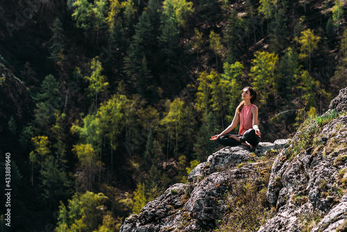 Attractive woman doing yoga. Healthy lifestyle. Woman doing yoga in the mountains. Girl doing yoga at sunrise. Woman meditates in nature. Meditation in the mountains. Copy space