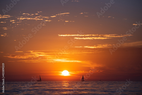 Calm sea with sunset sky and sun through the clouds over. Ocean and sky background  seascape.