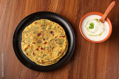 Palak paratha spinach paratha , parantha , chapati Indian flatbread roti made from spinach served with a yogurt mint dip and mango pickle, North Indian breakfast food Delhi India.