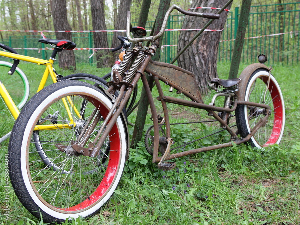 Old style rat look custom bicycle with handmade frame on green grass background outdoor at summer day