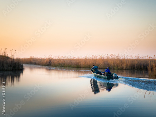Fishermen on their boat at canal of Oggau on lake neusiedl in Burgenland