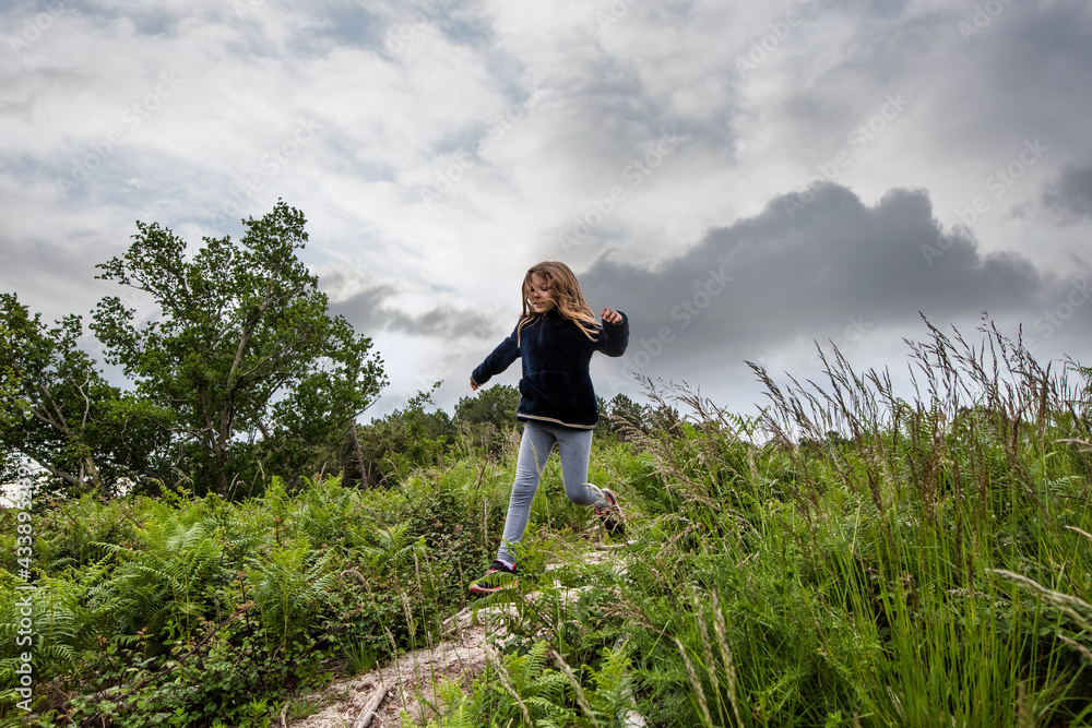 cute young girl running and jumping in nature in the rain cute young girl running and jumping in nature in the rain