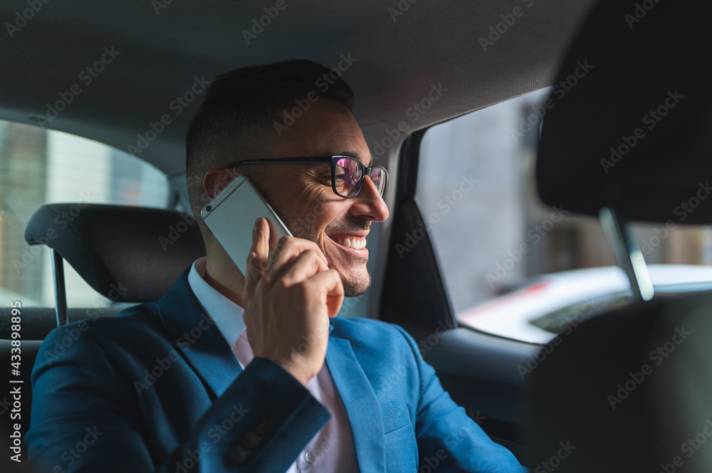 Businessman in the Back Seat of a Taxi Having Phone Call.