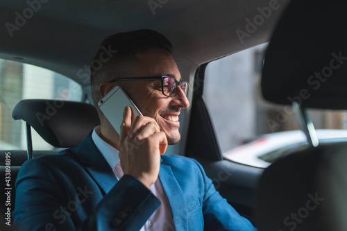 Businessman in the Back Seat of a Taxi Having Phone Call. © MCStock