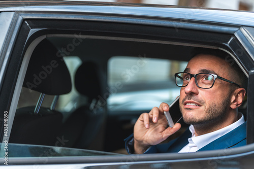 Businessman in the Back Seat of a Taxi Having Phone Call.