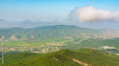 View of green mountains and villages in the valley. Wide angle panorama © Vastram