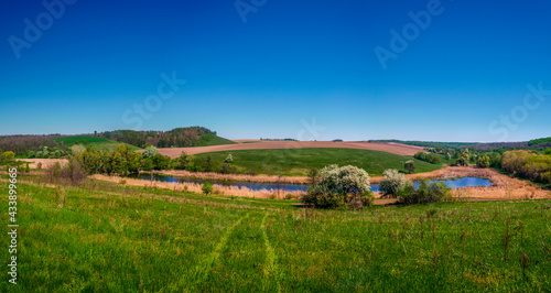 Panorama of green field blue lake and beautiful sky