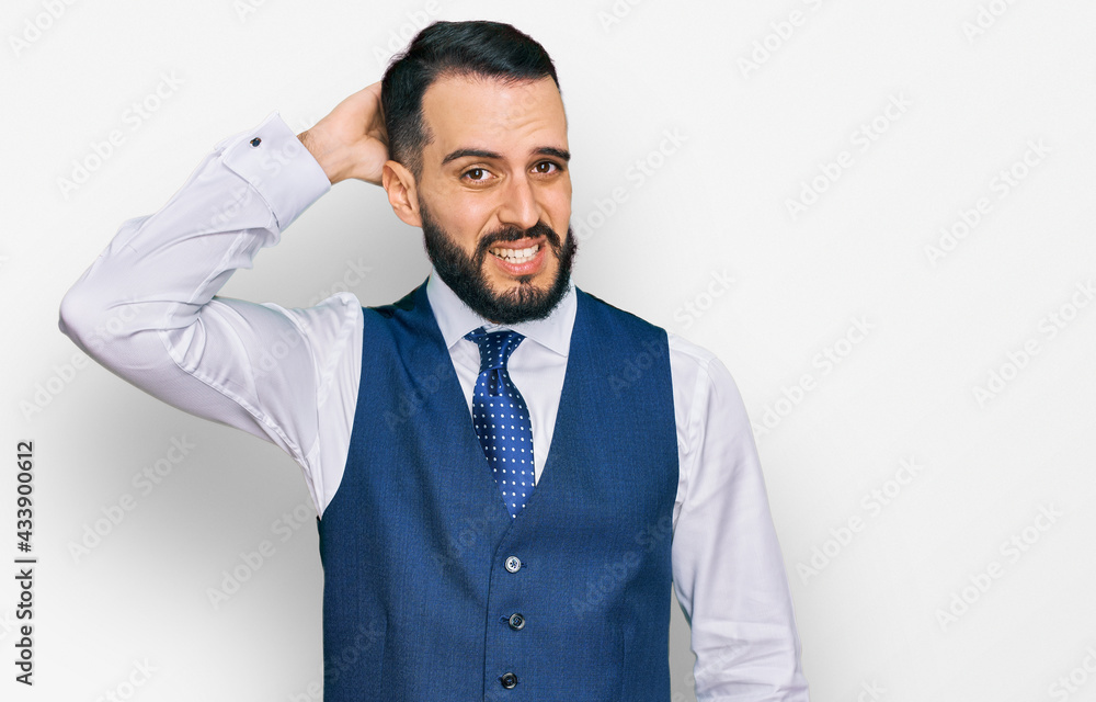 Young man with beard wearing business vest confuse and wonder about question. uncertain with doubt, thinking with hand on head. pensive concept. Young man with beard wearing business vest confuse and wonder about question. uncertain with doubt, thinking with hand on head. pensive concept.