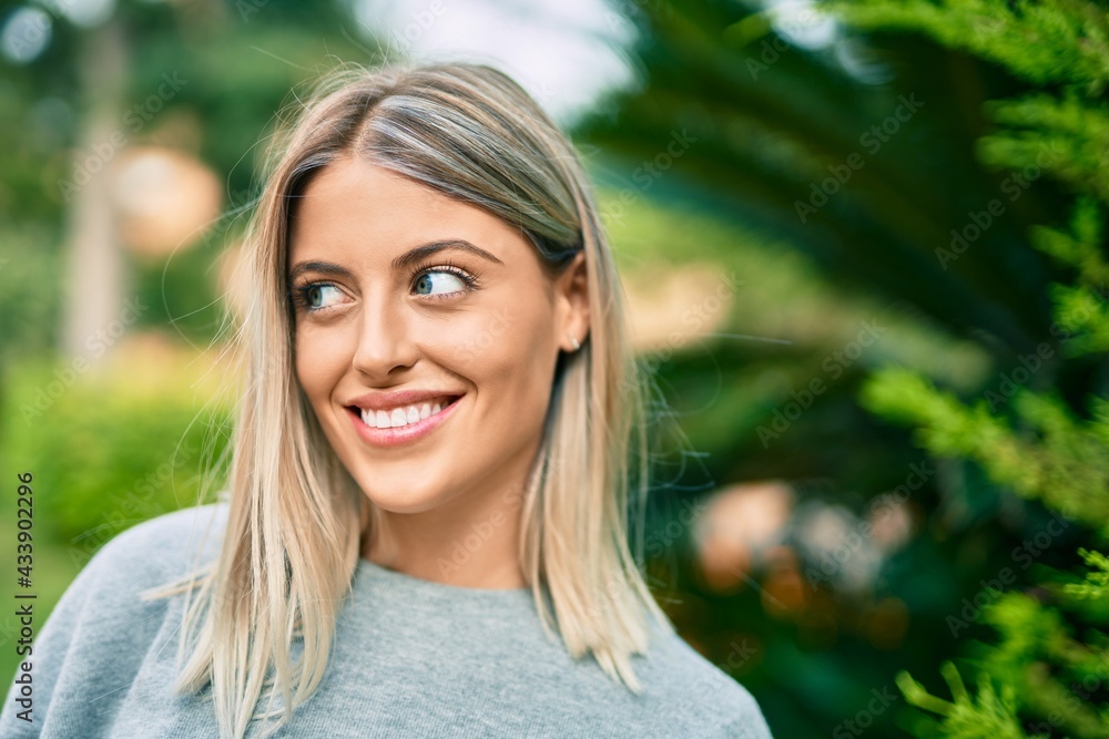 Young blonde girl smiling happy standing at the park. Young blonde girl smiling happy standing at the park.