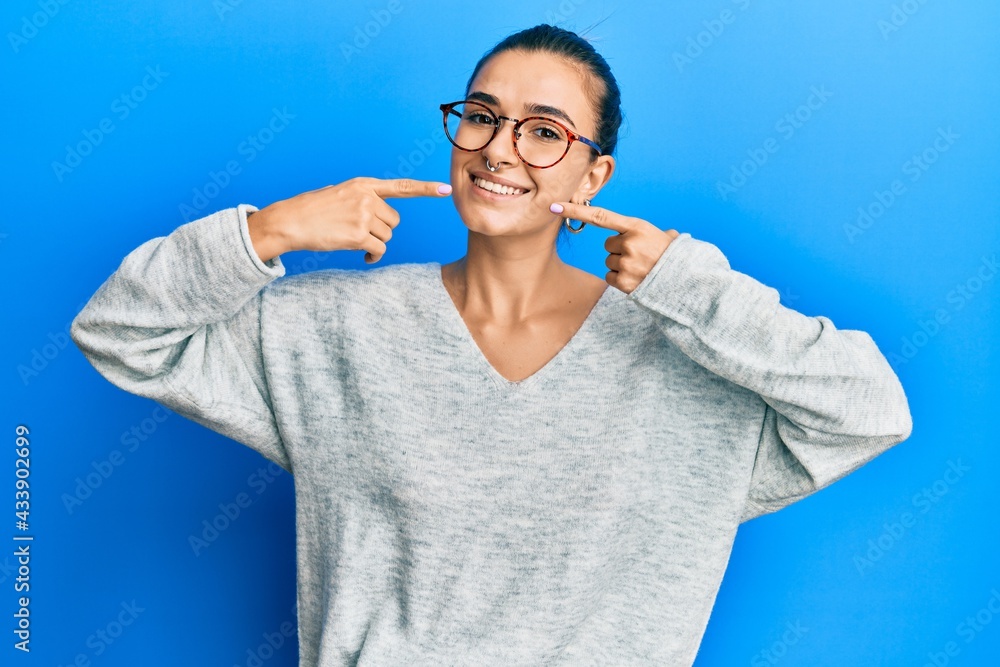 Young hispanic woman wearing casual clothes smiling cheerful showing and pointing with fingers teeth and mouth. dental health concept. Young hispanic woman wearing casual clothes smiling cheerful showing and pointing with fingers teeth and mouth. dental health concept.