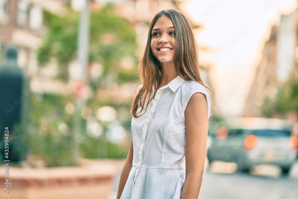 Beautiful latin teenager girl smiling happy standing at the city.