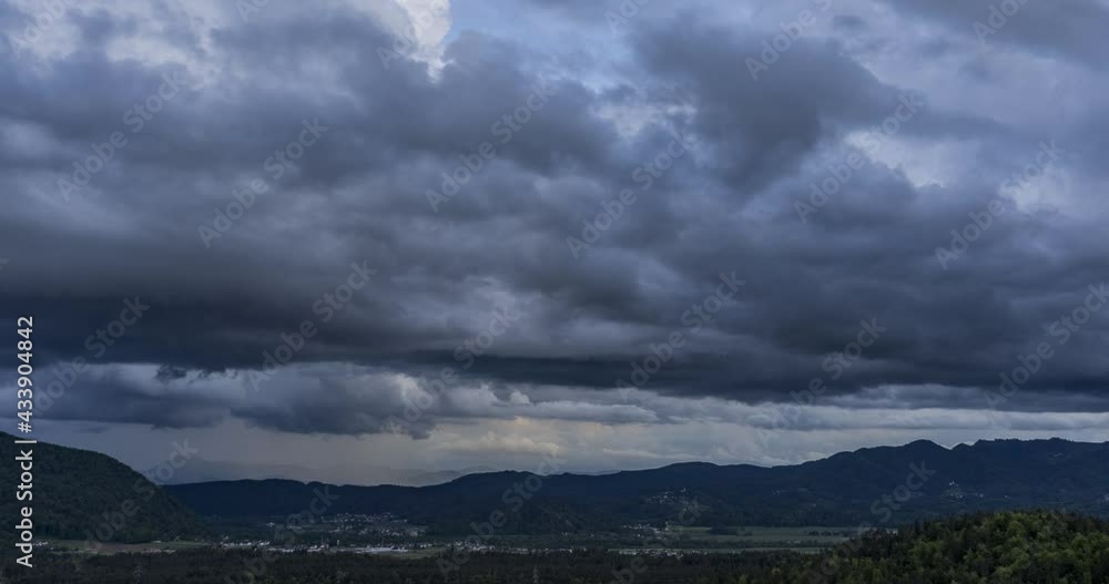 Time lapse of dark rainy clouds moving over hills and mountains in Slovenia. Dramatic sky with fast moving clouds. Left trucking, wide angle Time lapse of dark rainy clouds moving over hills and mountains in Slovenia. Dramatic sky with fast moving clouds. Left trucking, wide angle