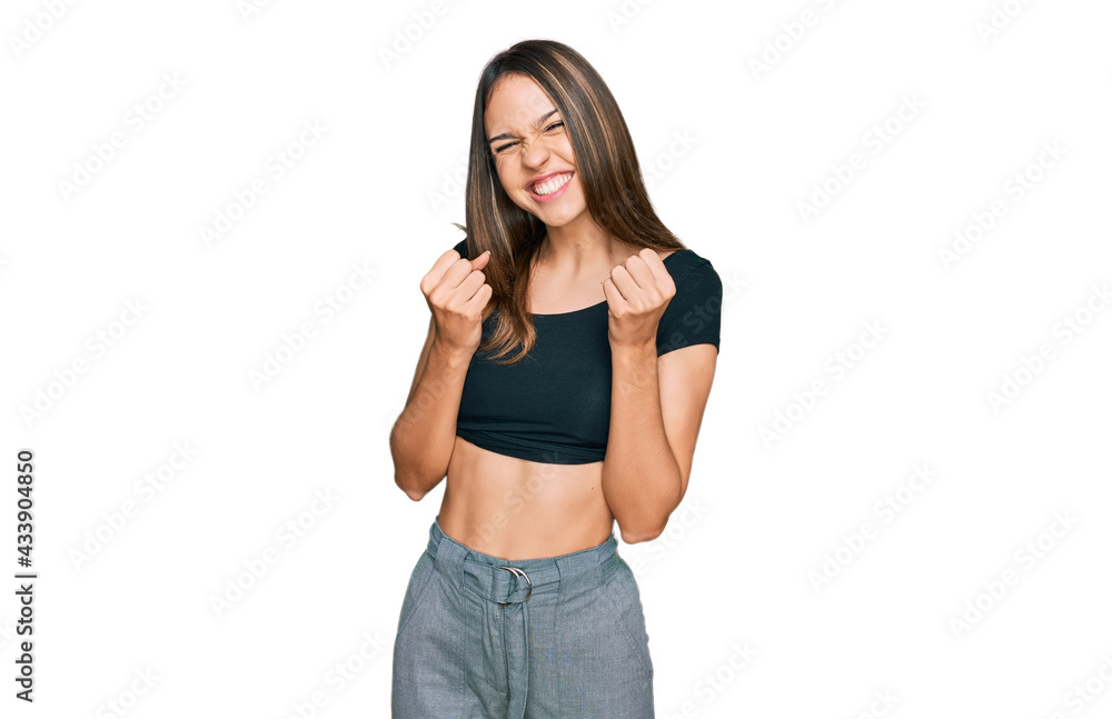 Young brunette woman wearing casual clothes excited for success with arms raised and eyes closed celebrating victory smiling. winner concept. Young brunette woman wearing casual clothes excited for success with arms raised and eyes closed celebrating victory smiling. winner concept.