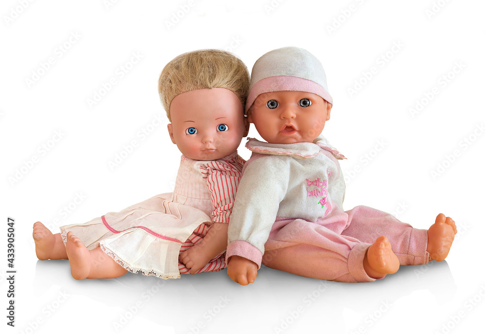 Tiny tots dolls in pink clothes. Nursery dolls sitting back to back, isolated on white background. Caucasian newborn baby puppets. Studio shot. Pair of figureheads sitting behind another. Tiny tots dolls in pink clothes. Nursery dolls sitting back to back, isolated on white background. Caucasian newborn baby puppets. Studio shot. Pair of figureheads sitting behind another.