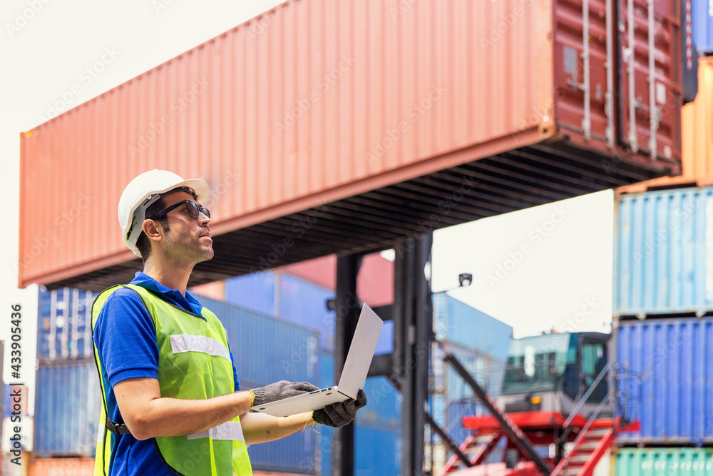 Foreman is giving a signal to work in the harbor. To move the cargo container onto the ship. Foreman is giving a signal to work in the harbor. To move the cargo container onto the ship.