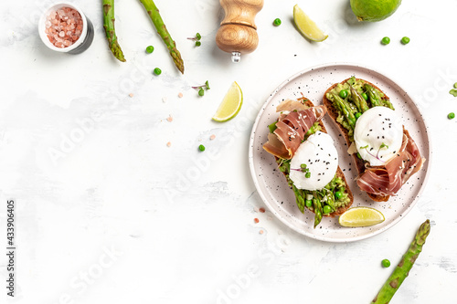 Ketogenic diet healthy breakfast asparagus with prosciutto, avocado and Benedict Poached eggs. Healthy food, diet lunch concept. Keto Paleo diet menu, top view
