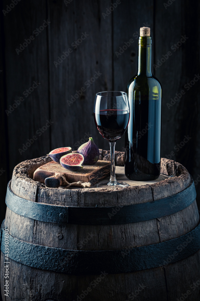 Wine in glass and figs on barrel. Wine industry.