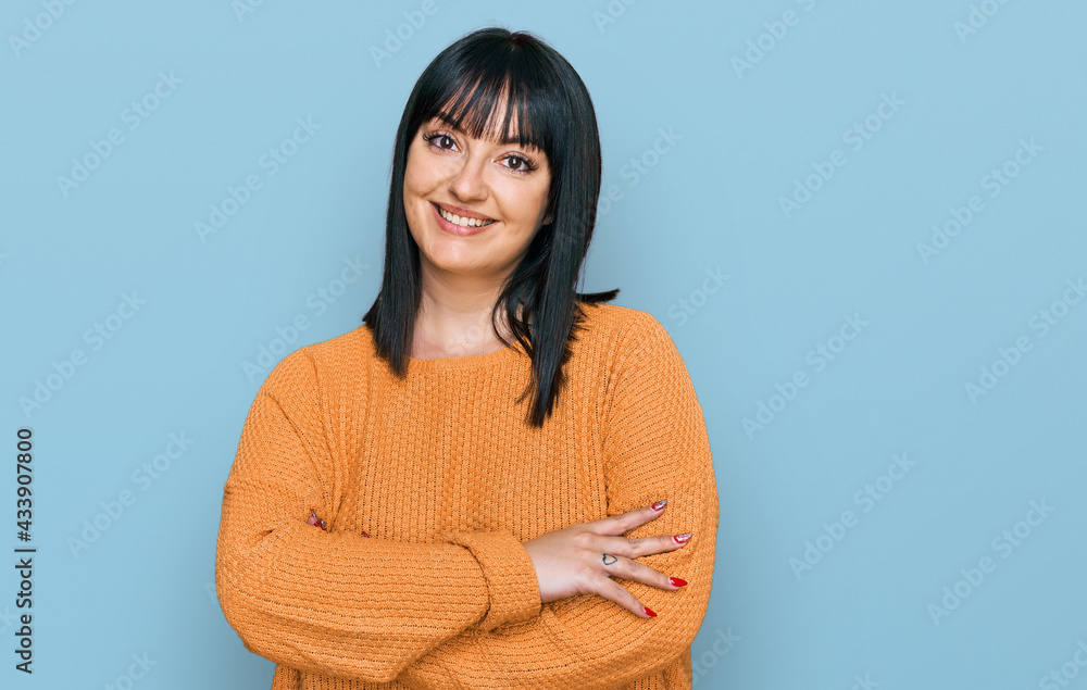 Young hispanic woman wearing casual clothes happy face smiling with crossed arms looking at the camera. positive person. Young hispanic woman wearing casual clothes happy face smiling with crossed arms looking at the camera. positive person.