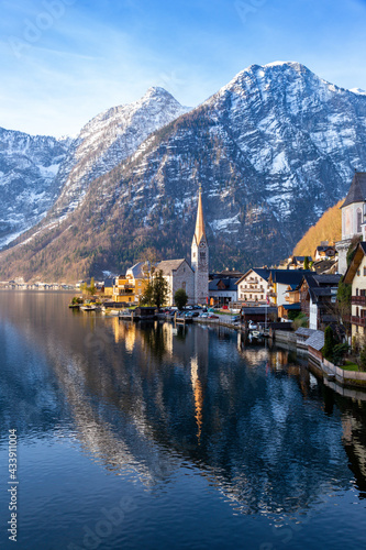 VIew of beautiful Hallstatt lake and famous church during morning sunrise in early spring