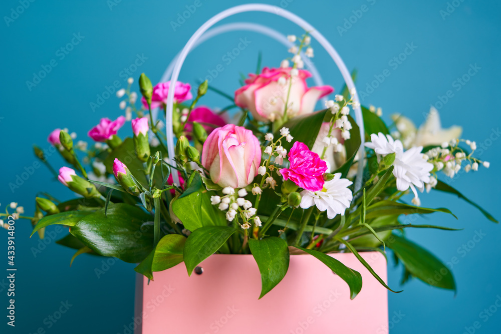 a bouquet of flowers is in a pink bag