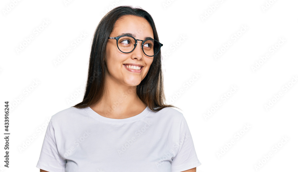 Young hispanic woman wearing casual white t shirt looking away to side with smile on face, natural expression. laughing confident. Young hispanic woman wearing casual white t shirt looking away to side with smile on face, natural expression. laughing confident.