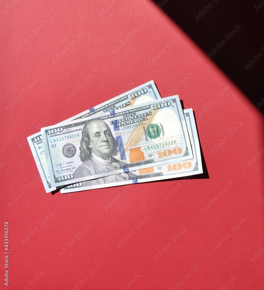 American Dollars In The Red Background Three One Hundred Dollar american-dollars-in-the-red-background-three-one-hundred-dollar