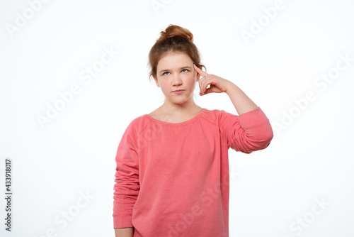 Wallpaper Mural Young girl pointing to head with one finger, great idea or thought, good memory. Be smart and think Torontodigital.ca