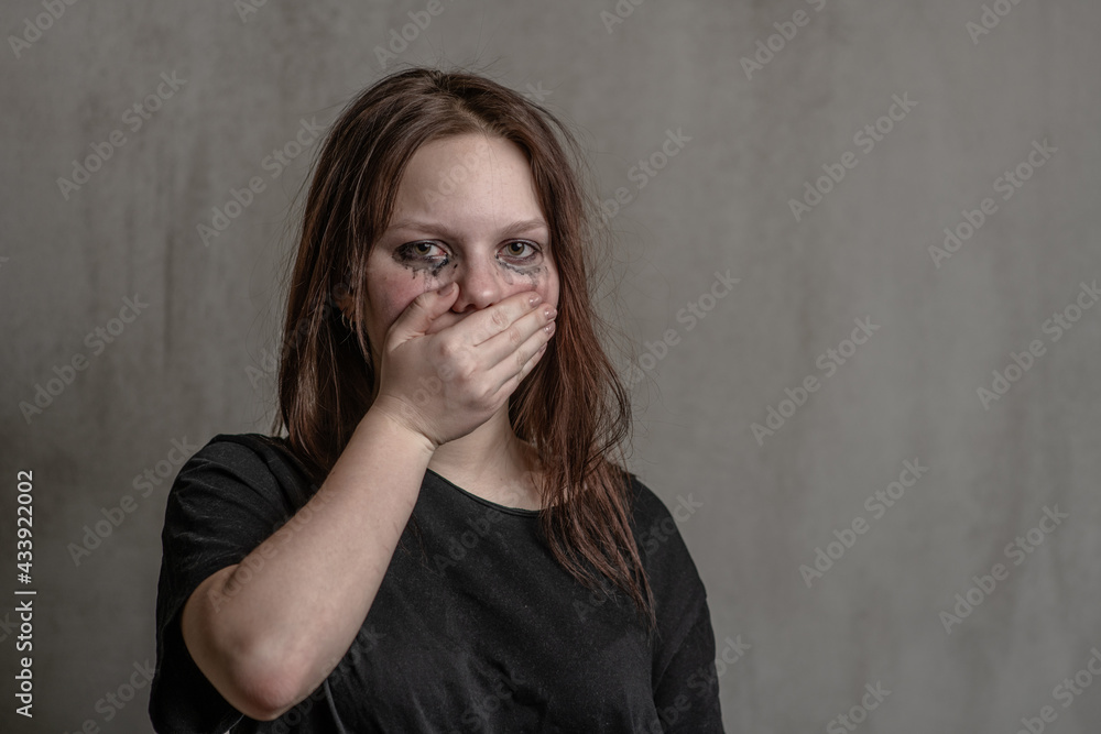 Frightened girl covers her mouth with her hands. Empty space for text Frightened girl covers her mouth with her hands. Empty space for text