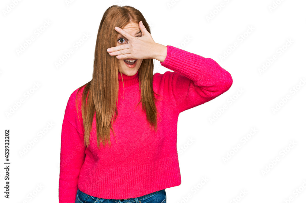 Young irish woman wearing casual clothes peeking in shock covering face and eyes with hand, looking through fingers with embarrassed expression. Young irish woman wearing casual clothes peeking in shock covering face and eyes with hand, looking through fingers with embarrassed expression.