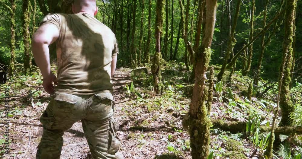 handsome brutal man sportsman jogging in the forest in special khaki clothes. handsome brutal man sportsman jogging in the forest in special khaki clothes.