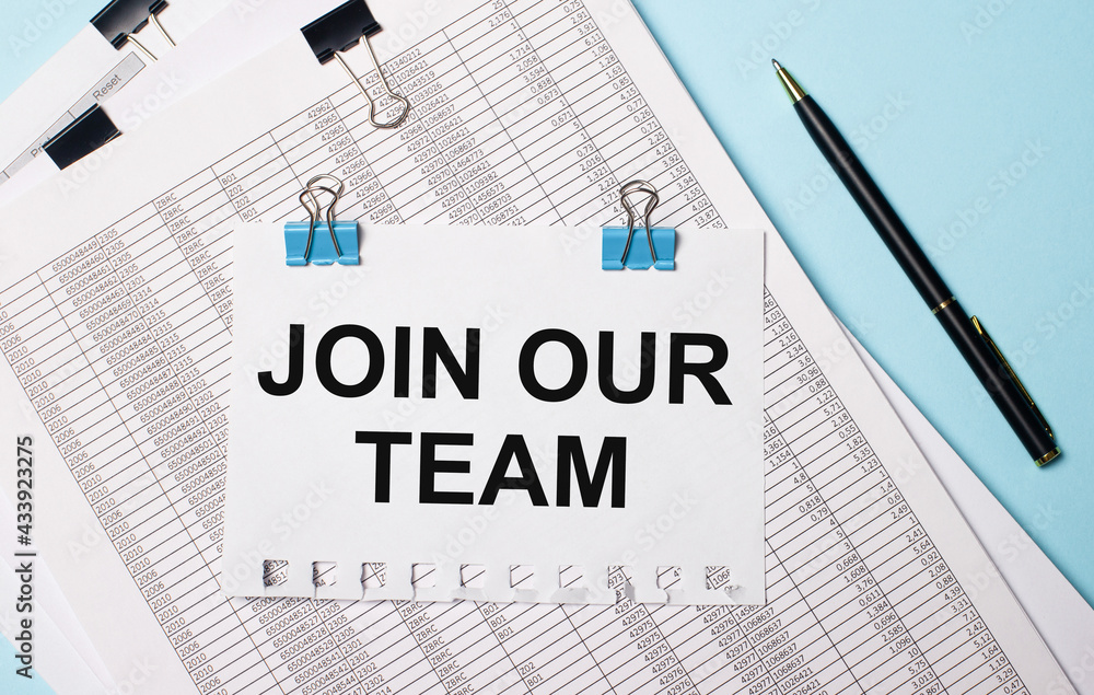 On a light blue background, documents, a pen and a sheet of paper on blue paper clips with the text JOIN OUR TEAM. Business concept. On a light blue background, documents, a pen and a sheet of paper on blue paper clips with the text JOIN OUR TEAM. Business concept.