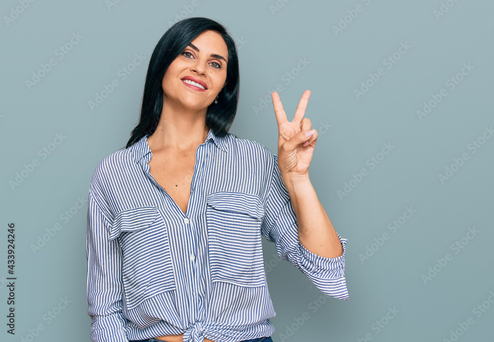 Young caucasian woman wearing casual clothes smiling looking to the camera showing fingers doing victory sign. number two. Young caucasian woman wearing casual clothes smiling looking to the camera showing fingers doing victory sign. number two.