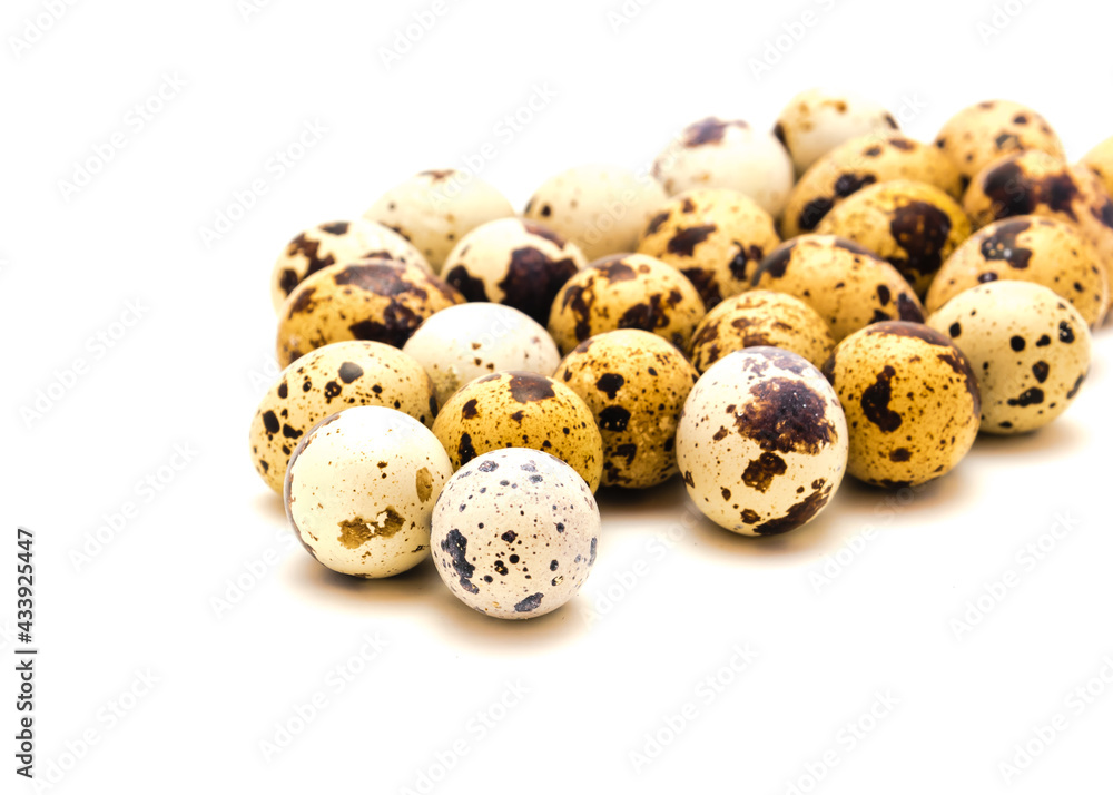 Shallow DOF studio shot heap of quail eggs isolated on white background with copy space Shallow DOF studio shot heap of quail eggs isolated on white background with copy space