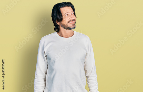 Middle age caucasian man wearing casual clothes smiling looking to the side and staring away thinking.