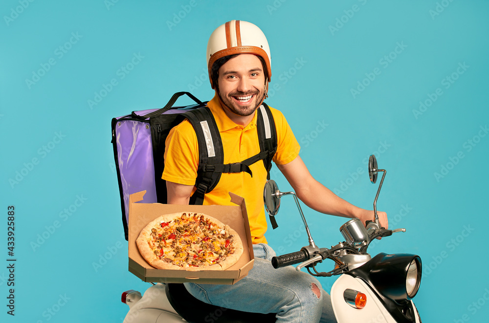 Young courier, pizza delivery man in uniform with thermo backpack on a  moped isolated on blue background. Fast transport express home delivery.  Online order. Stock Photo | Adobe Stock