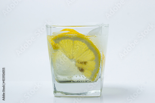 Lemon with ice in a glass. Refreshing drink with lemon. Cold cocktail