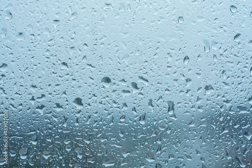 Raindrops on the transparent window pane in rainy weather.