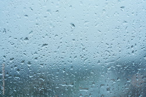 Raindrops on the transparent window pane in rainy weather.