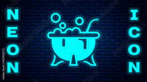 Glowing neon Halloween witch cauldron icon isolated on brick wall background. Happy Halloween party. Vector