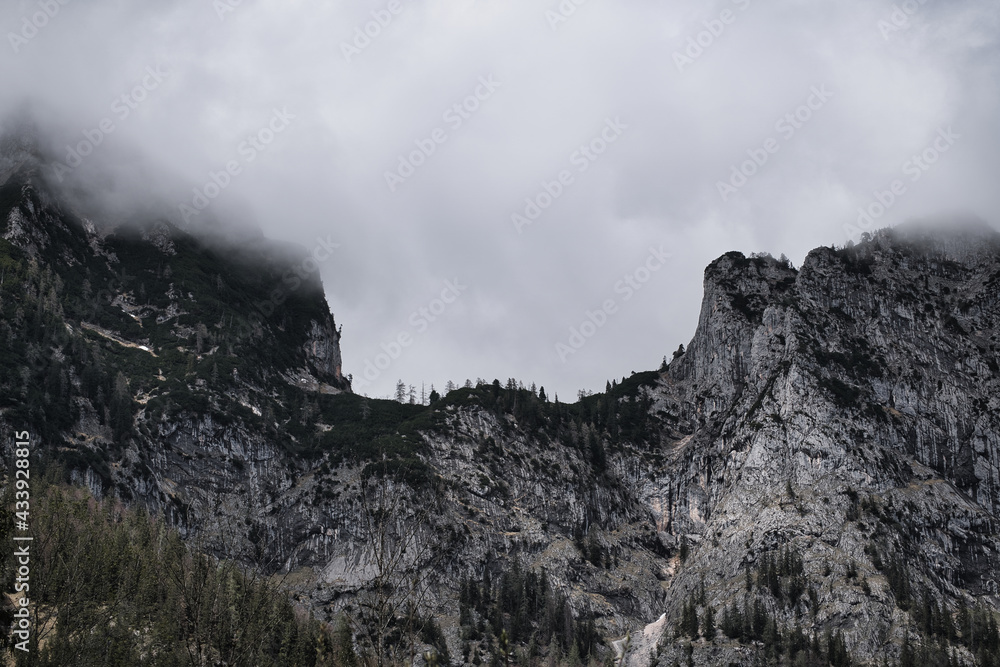 Dark mood - dramatic clouds and fogs over the mountains and parts with snow Dark mood - dramatic clouds and fogs over the mountains and parts with snow