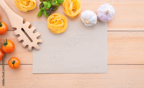 Food background for tasty Italian dishes with blank brown paper and vintage pasta ladle on wooden background. Top view italian foods concept and menu design with copy space.