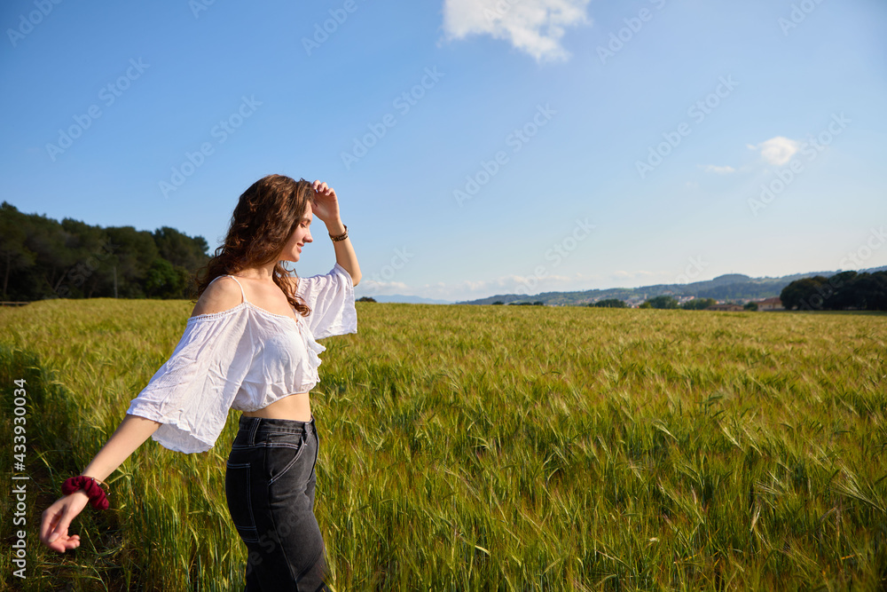 woman in a green wheat field on sunny day