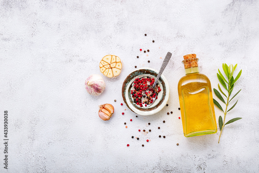 Glass bottle of olive oil and olive branch set up on white concrete background. Glass bottle of olive oil and olive branch set up on white concrete background.