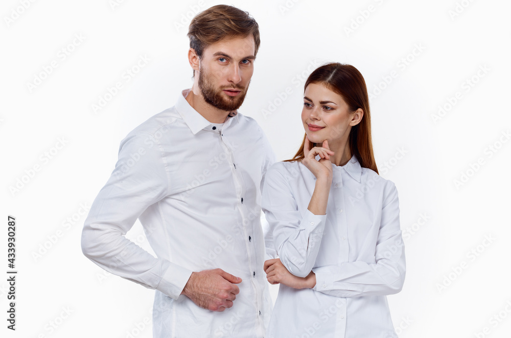 a man and a woman in identical shirts are gesticulating with their hands on a light background. a man and a woman in identical shirts are gesticulating with their hands on a light background.
