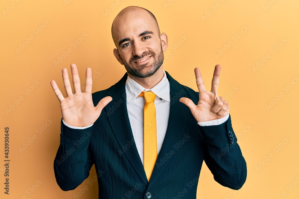 Young hispanic man wearing business suit and tie showing and pointing up with fingers number eight while smiling confident and happy. Young hispanic man wearing business suit and tie showing and pointing up with fingers number eight while smiling confident and happy.