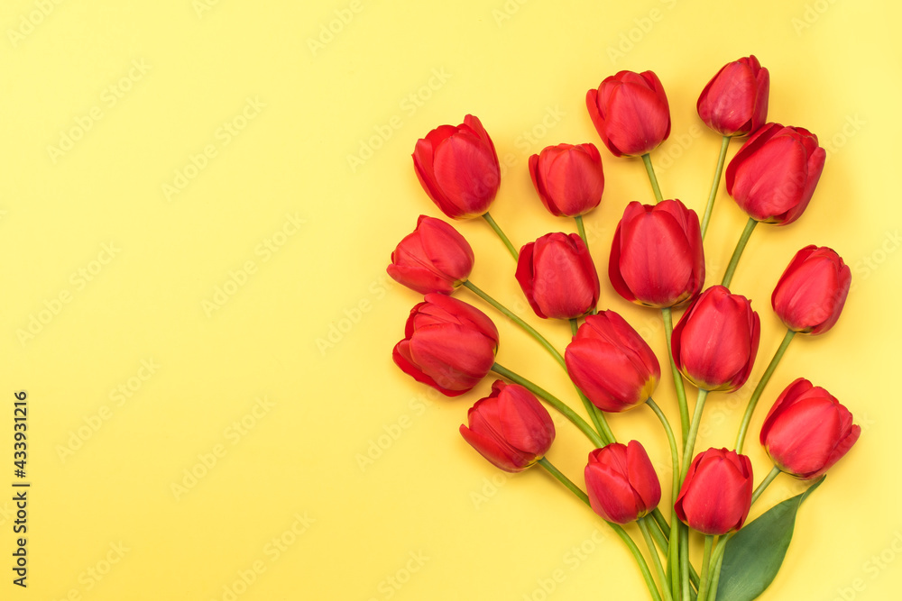 Bouquet red tulips on a yellow background, flat lay, copy space. Flower background Bouquet red tulips on a yellow background, flat lay, copy space. Flower background