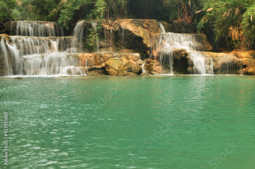 Tat Kuang Si Waterfalls or Kuang Xi Falls for Laotian people and foreign travelers travel visit and play swimming shallow water pools atop a steep hillside in nation park at Luang Prabang, Laos