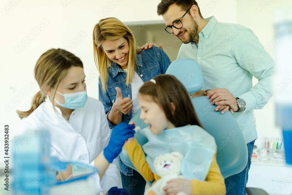 The doctor shows to girl and parents how the prosthesis is used and how it affects the teeth. The doctor shows to girl and parents how the prosthesis is used and how it affects the teeth.