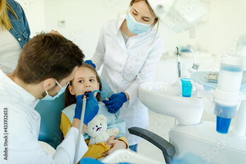 Little girl is not afraid to show teeth to dentist. Prophylactic examinations child at dentist.