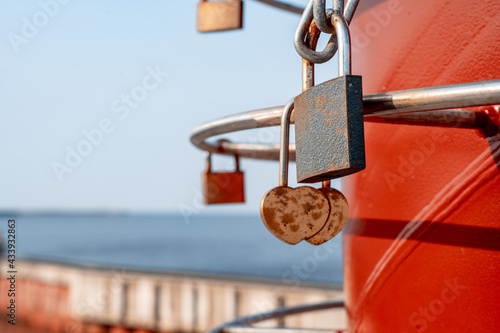 Metal padlocks covered with rust, hanging by the lovers on iron railings on the pier (823)